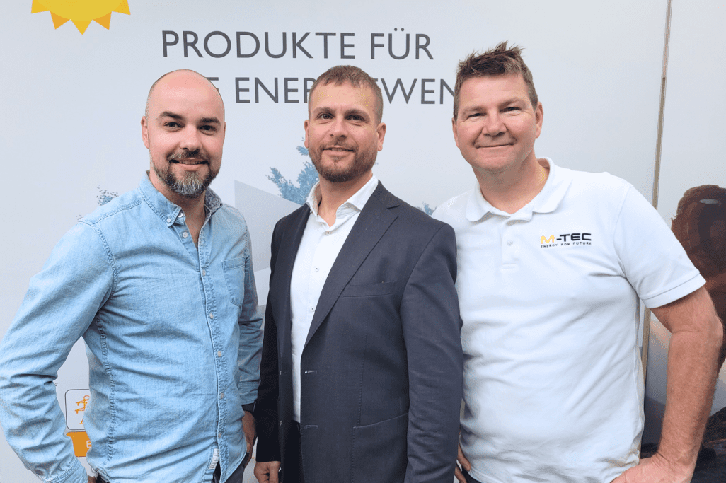 eine Gruppe von Männern, die vor einem Schild stehen